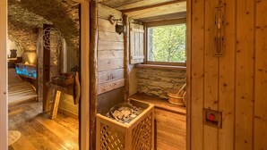 A rustic wooden interior with a stone wall, a window with a view, a wooden bench, and a fireplace. - Chalet 'Civico 11' with Mountain View, Balcony and Wi-Fi (Marmora)