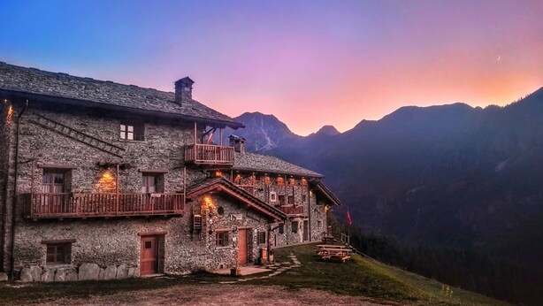 A stone building with a balcony, a staircase, and a view of mountains. - Chalet 'Civico 11' with Mountain View, Balcony and Wi-Fi (Marmora)