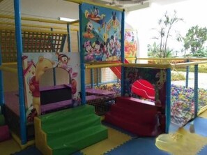 Zona de jocs per a infants amb espai de joc tou, bressol de pilotes i estructura per escalar.