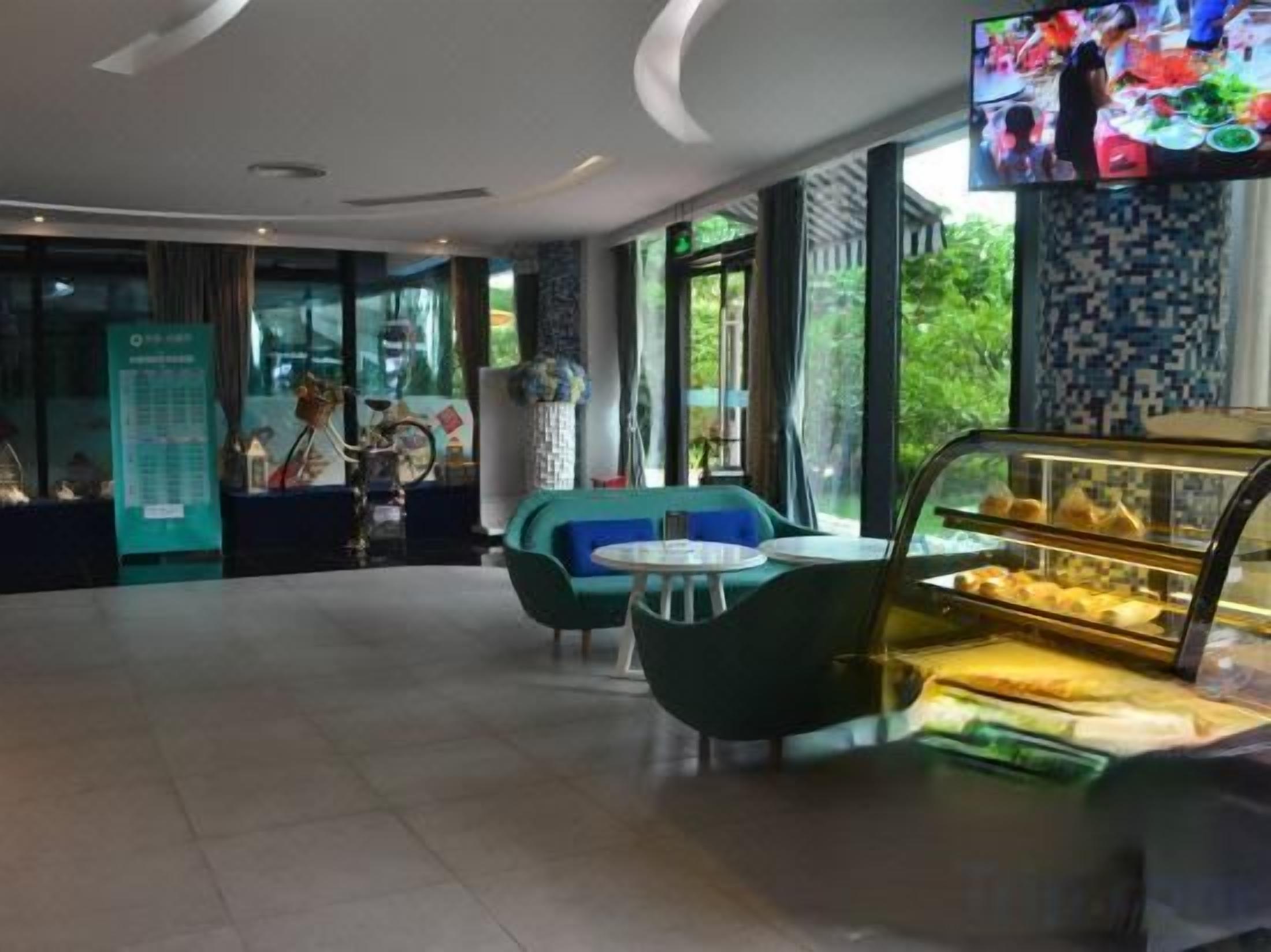 Ein modernes Interieur mit Sitzbereichen, einer Vitrine und einem Fernsehbildschirm.