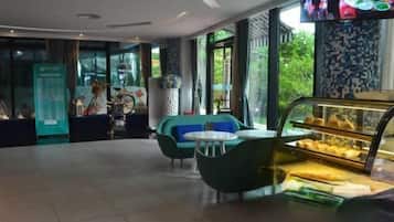 Ein modernes Interieur mit Sitzbereichen, einer Vitrine und einem Fernsehbildschirm.
