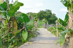 A pathway leading through a garden with a concrete surface and surrounded by greenery. - Laimeng Shuixiewan Haiyi Holiday Apartment (Huidong)