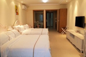 Une chambre d’hôtel avec deux lits, une télévision, une petite table et une armoire.