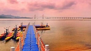 Une jetée avec des kayaks aux couleurs vives et un pont en arrière-plan.