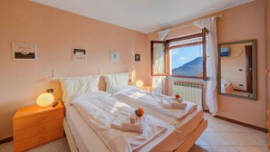 Une chambre d’hôtel comprenant un lit, des tables de chevet, une commode, une fenêtre avec vue et un miroir.