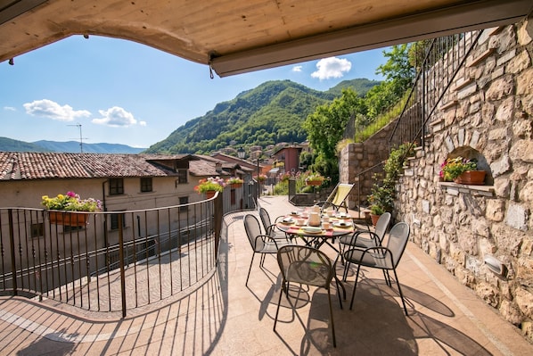 A terrace with a table and chairs, overlooking a mountainous landscape. - Casa Angiolina Lake & Mountain View (Tremosine)