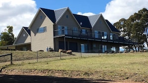 A large, modern two-story house with a flat roof and multiple windows.