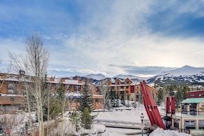 A mountain resort with wooden buildings, a ski lift, and snow-covered slopes.