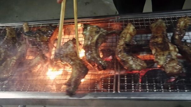 A grill with meat being cooked. - Caiyunjian Inn (Shangri-La)