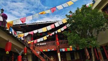 A traditional building with a wooden staircase and colorful flags.