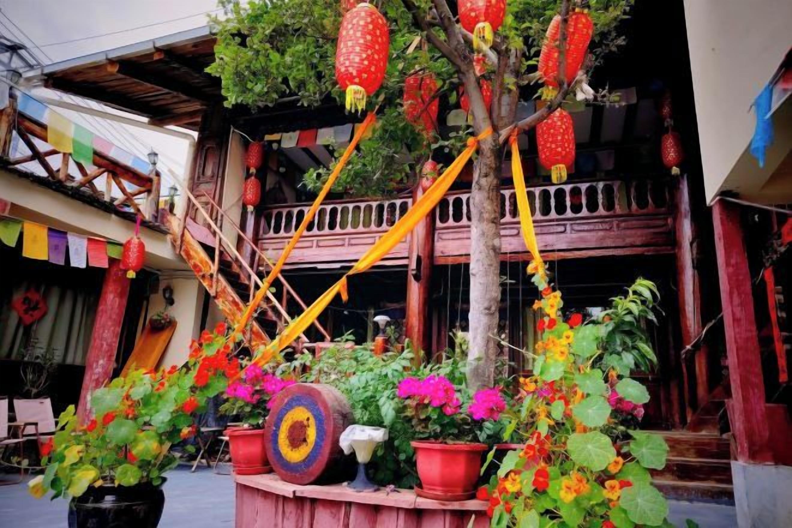 A traditional building with a balcony, potted plants, and hanging decorations.