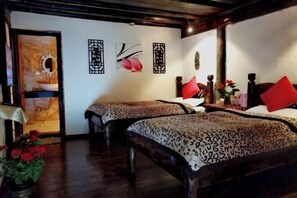 A room with two beds, a wooden ceiling, and a wall with artwork. - Caiyunjian Inn (Shangri-La)