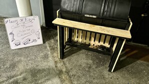 A small, portable grill with a wooden side table, placed on a concrete floor. - Royal Guest Inn (Nuwara Eliya)