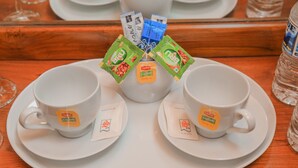 A tray with two white cups and saucers, each with a tea bag and a napkin. - Royal Guest Inn (Nuwara Eliya)