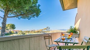 Un balcon avec une table et des chaises, une vue sur un parc aquatique et un ciel dégagé.