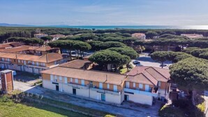 Un quartier résidentiel où les bâtiments sont coiffés de toits en tuiles de terre cuite, le tout entouré d’une végétation luxuriante et d’arbres.