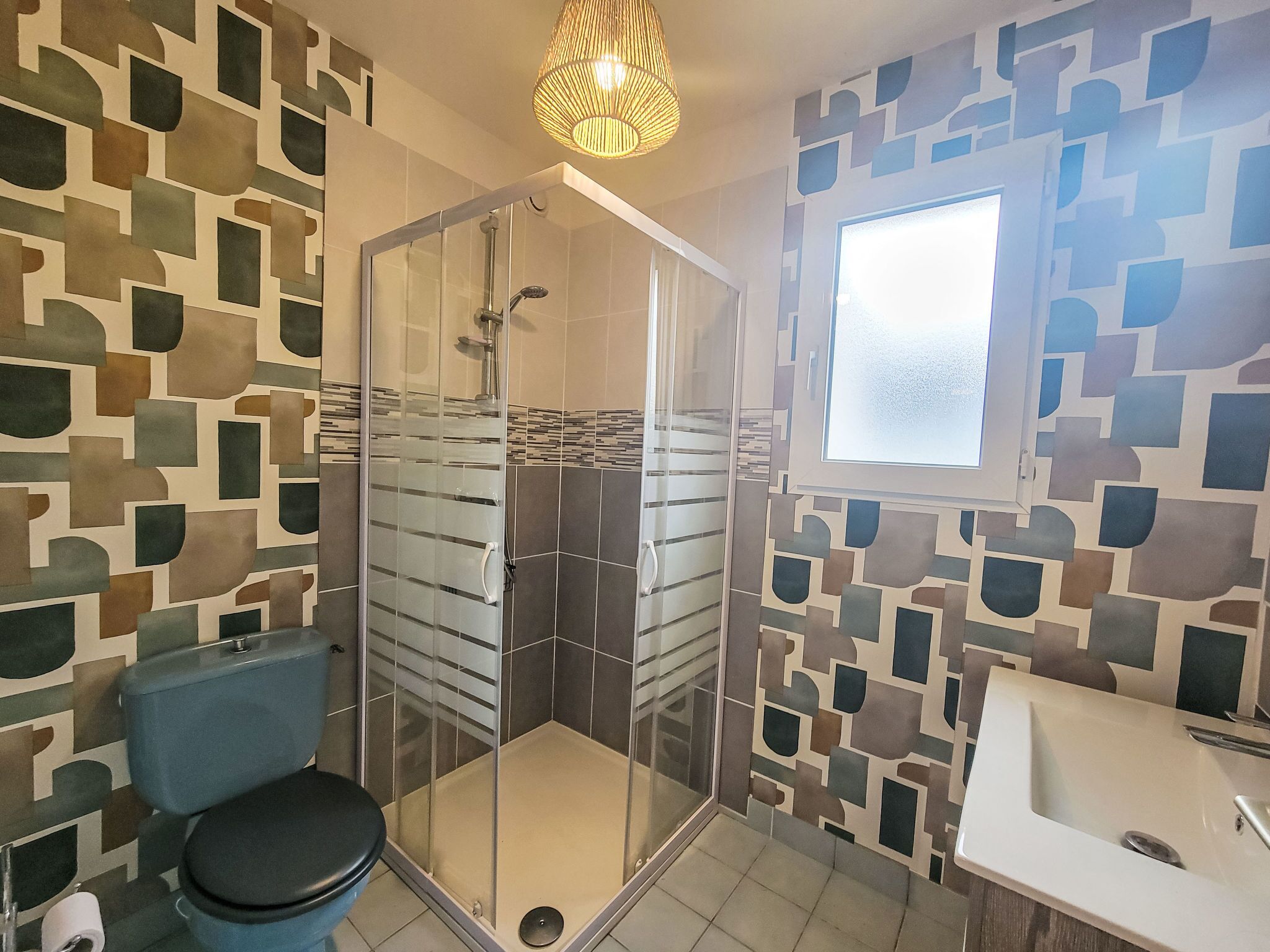 Un bagno con doccia vetrata, un water e un lavandino.