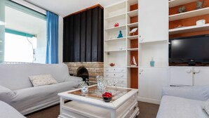 A modern living room with a fireplace, white furniture, and a TV. - Acantilados by Interhome (Salou)