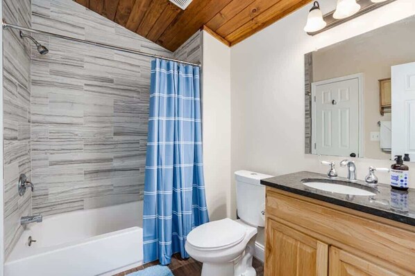 Bathtub, hair dryer, towels, shampoo