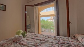 Une chambre à coucher avec un lit, une fenêtre et une vue sur le balcon extérieur.