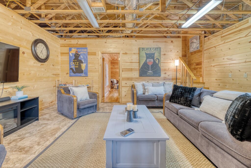 A cozy log cabin interior with a living room featuring a sofa, a coffee table, and a TV stand.