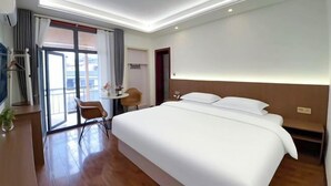 A modern hotel room with a large bed, a desk with a chair, and a small table. - No. 1 Inn @ the Corner (Zhangjiajie)