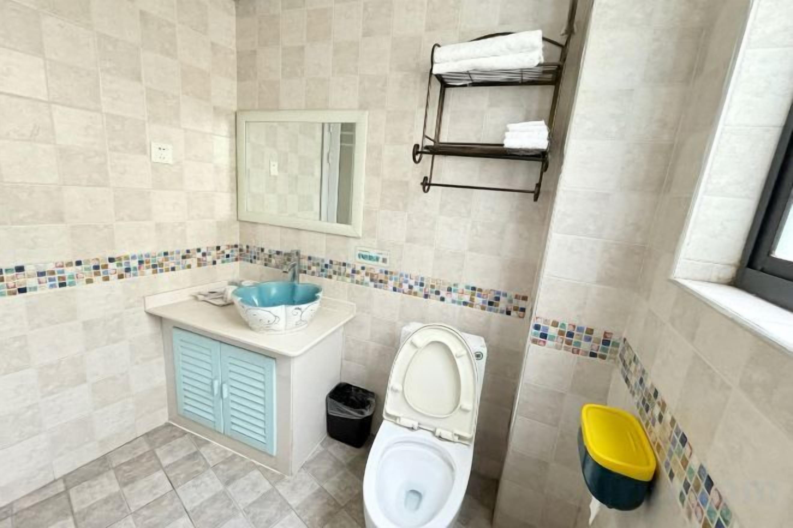A bathroom with a sink, toilet, and a mirror.