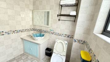 A bathroom with a sink, toilet, and a mirror.