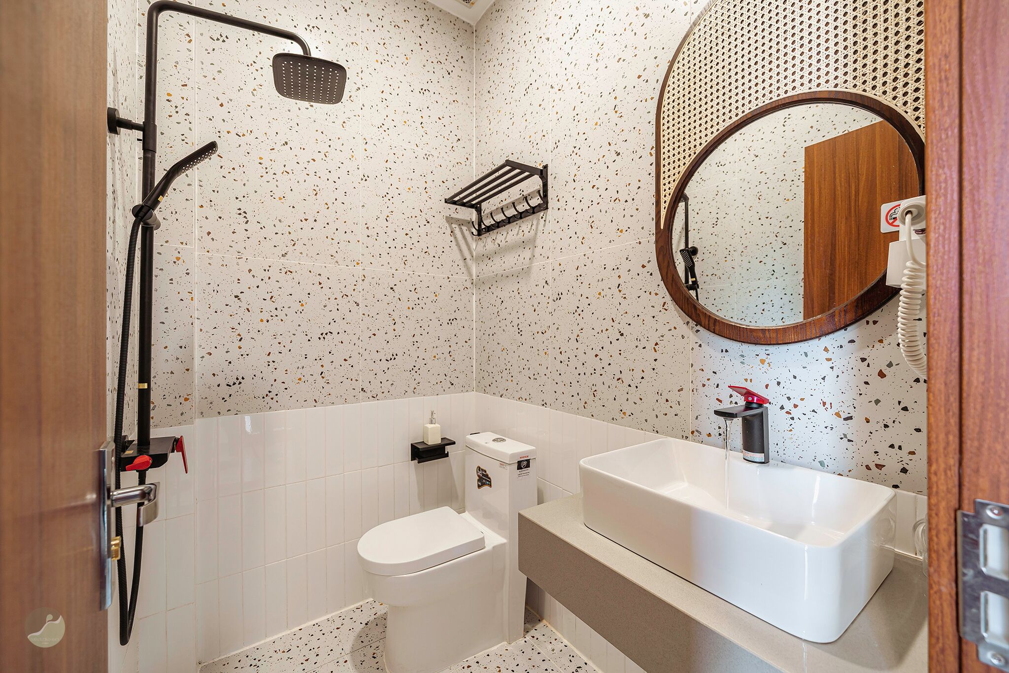 A bathroom with a shower, toilet, sink, and mirror.