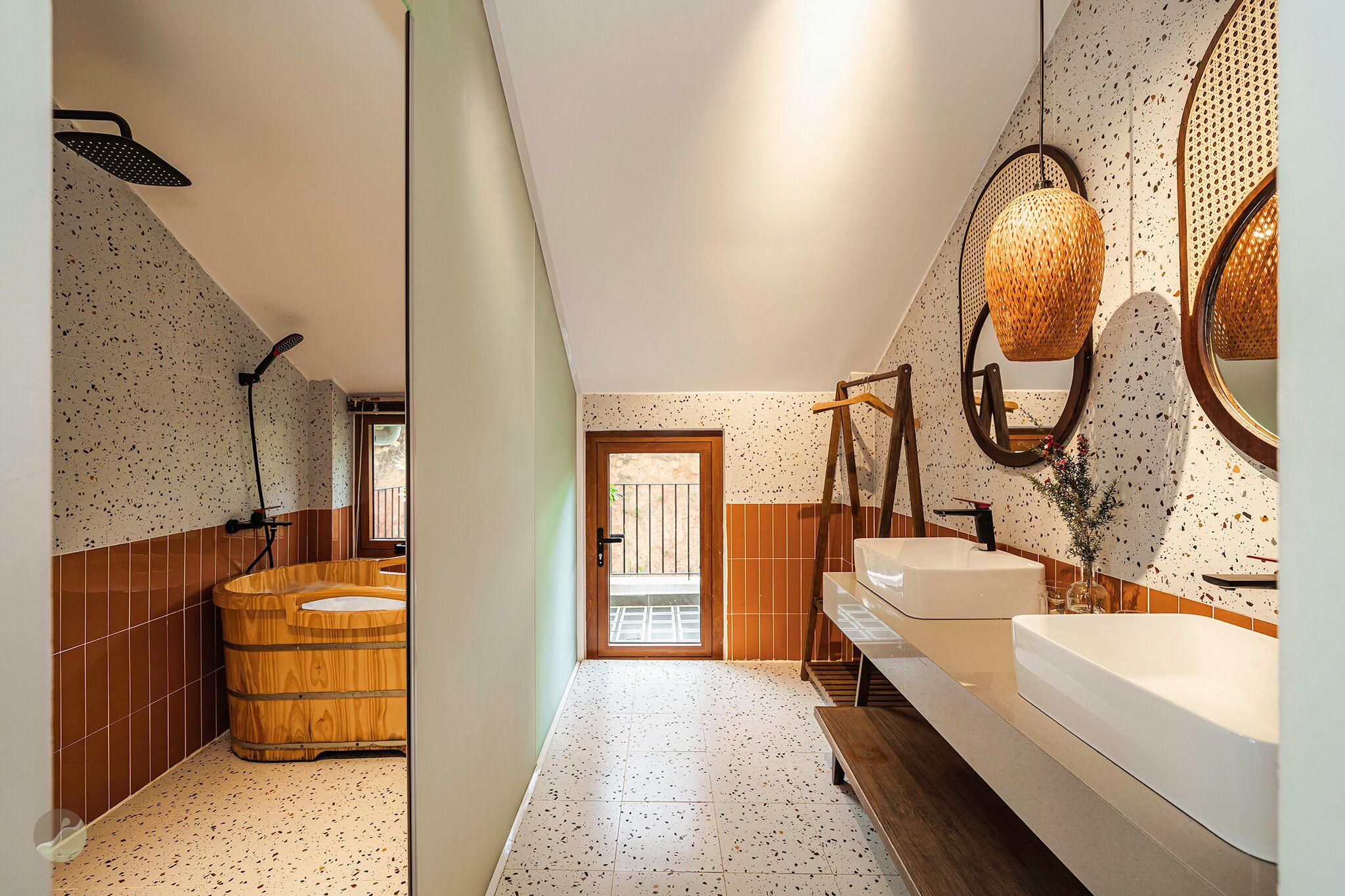 A bathroom with a wooden bathtub, a large mirror, and a sink.