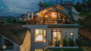 A two-story house with a balcony, large windows, and a view of the surrounding landscape. - Mien Suong Khoi - Home & Cafe (Xuan Truong - Da Lat)
