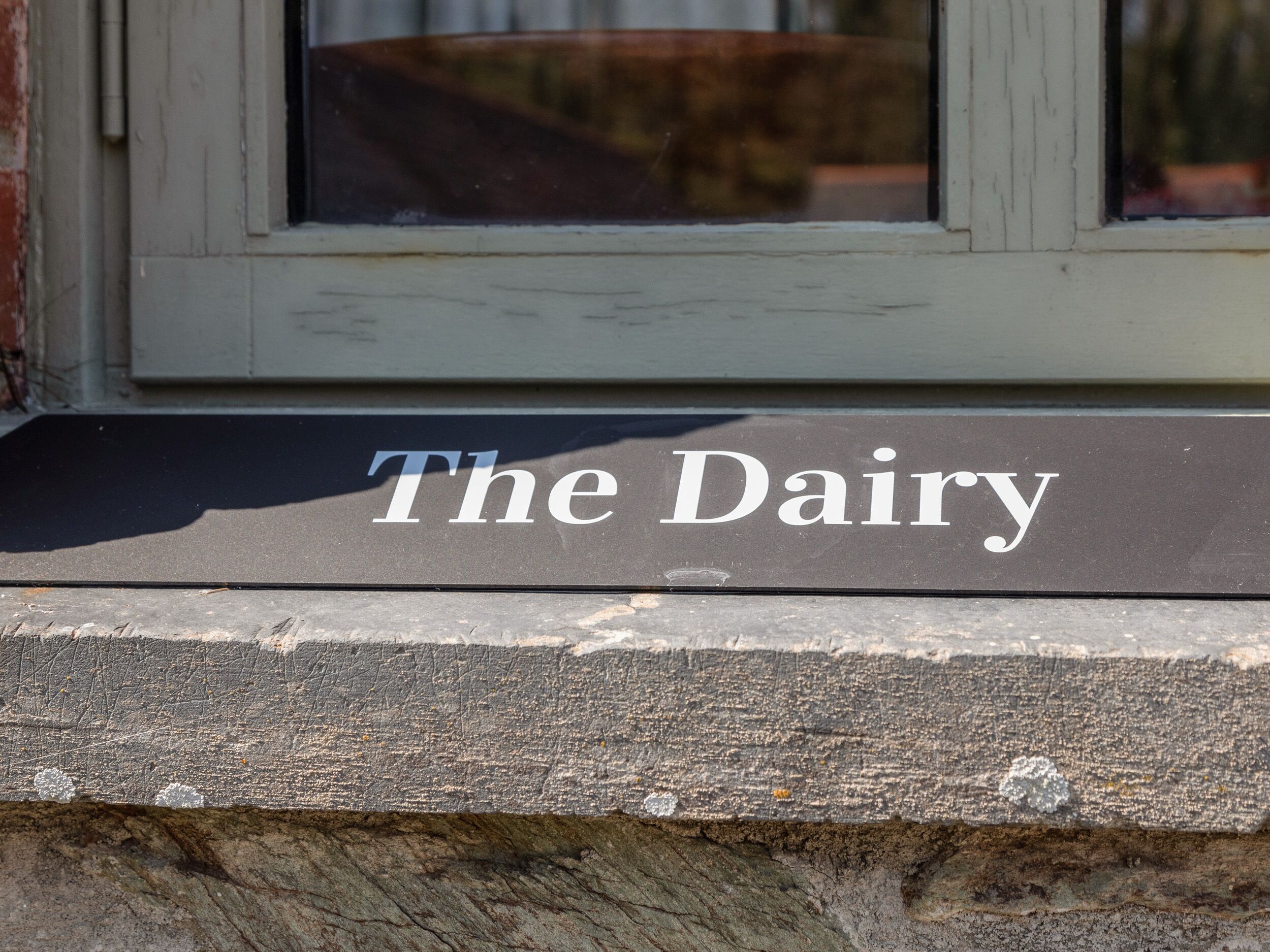 Een bord met de tekst 'The Dairy' op een gevel.
