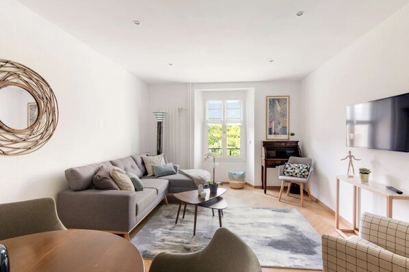 Apartamento básico, 1 cama Queen | Área de estar | TV de tela plana