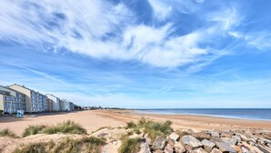 A beachside hotel with multiple buildings, a sandy beach, and a clear sky. - Duplex Etoile de mer- T4 Vue mer (Courseulles-sur-Mer)