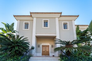 A two-story building with a symmetrical facade, a central entrance with a double door, and two windows on each side. - Villa Breena - Quinta do Mar (Quinta do Lago)