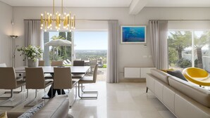 Un espace repas moderne avec une grande table, des chaises et un lustre.