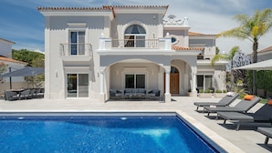 A two-story house with a swimming pool, outdoor seating, and a balcony. - Villa Flamingo - Quinta do Mar  (Vale do Lobo)