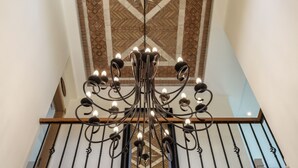A staircase with a decorative ceiling and a chandelier.