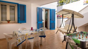 Un patio con una mesa de futbolín, una mesa con sillas y una mesa cubierta con mantel.