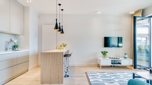 A modern kitchen with a central island, bar stools, and pendant lighting.