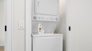 A front-loading washing machine with Tide detergent on top. - Wake Up to Bay Views | Walk Downtown + Beach (Traverse City)