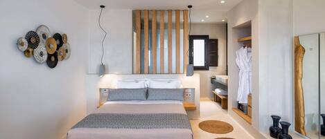A modern bedroom with a large bed, bedside tables, a mirror, and a wooden partition.