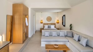 Une chambre d’hôtel moderne avec un grand lit, un canapé, une table basse en bois et une armoire.