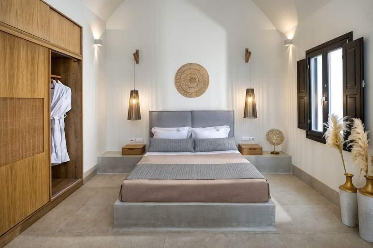 Une chambre à coucher comprenant un lit, des tables de chevet, une armoire et un élément décoratif circulaire fixé au mur.