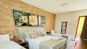 A hotel room with two beds, a brick accent wall, and a large window. - Pousada das Flores (Luis Correia)