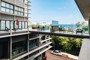 A modern building with multiple balconies overlooking a coastal area.