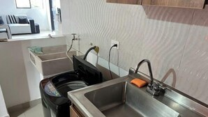 Una cocina moderna con un lavamanos de acero inoxidable, un lavavajillas y un horno empotrado.