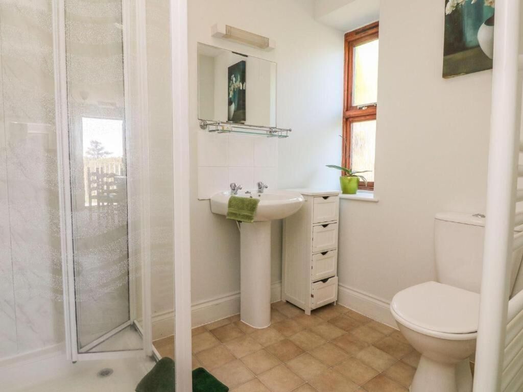 A bathroom with a shower, sink, and toilet.