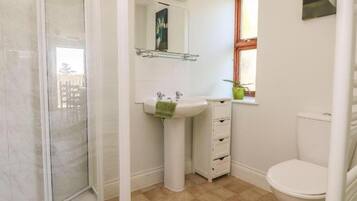 A bathroom with a shower, sink, and toilet.