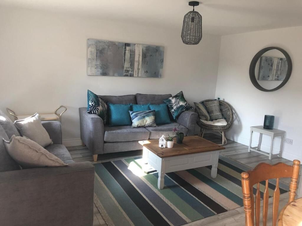 Un salon comprenant un canapé, des fauteuils, une table basse et un tapis.